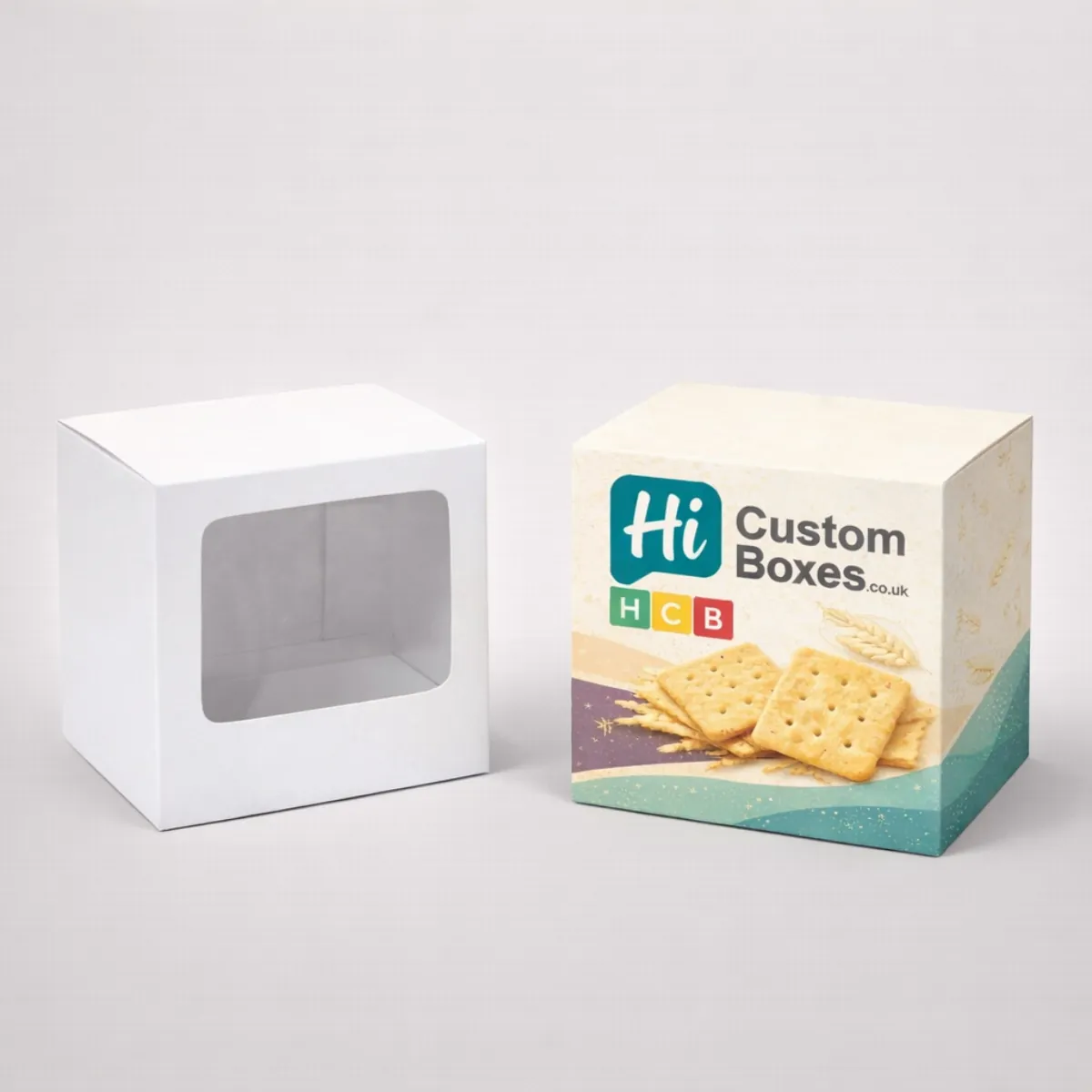 Square cracker packaging with a clear front window next to a printed branded box- class=